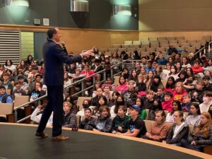 Mike Domitrz speaking to students during a consent and respect school assembly at a high school auditorium